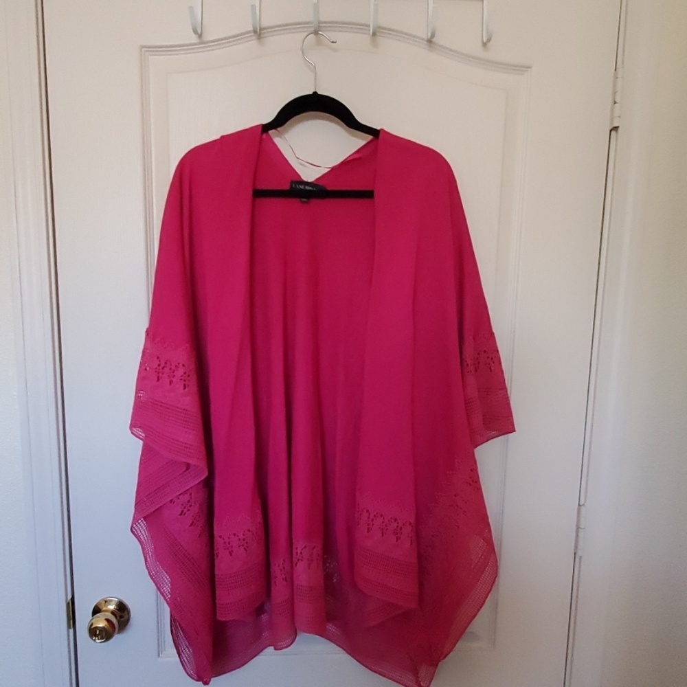 Fuchsia ruana with embroidered trim.